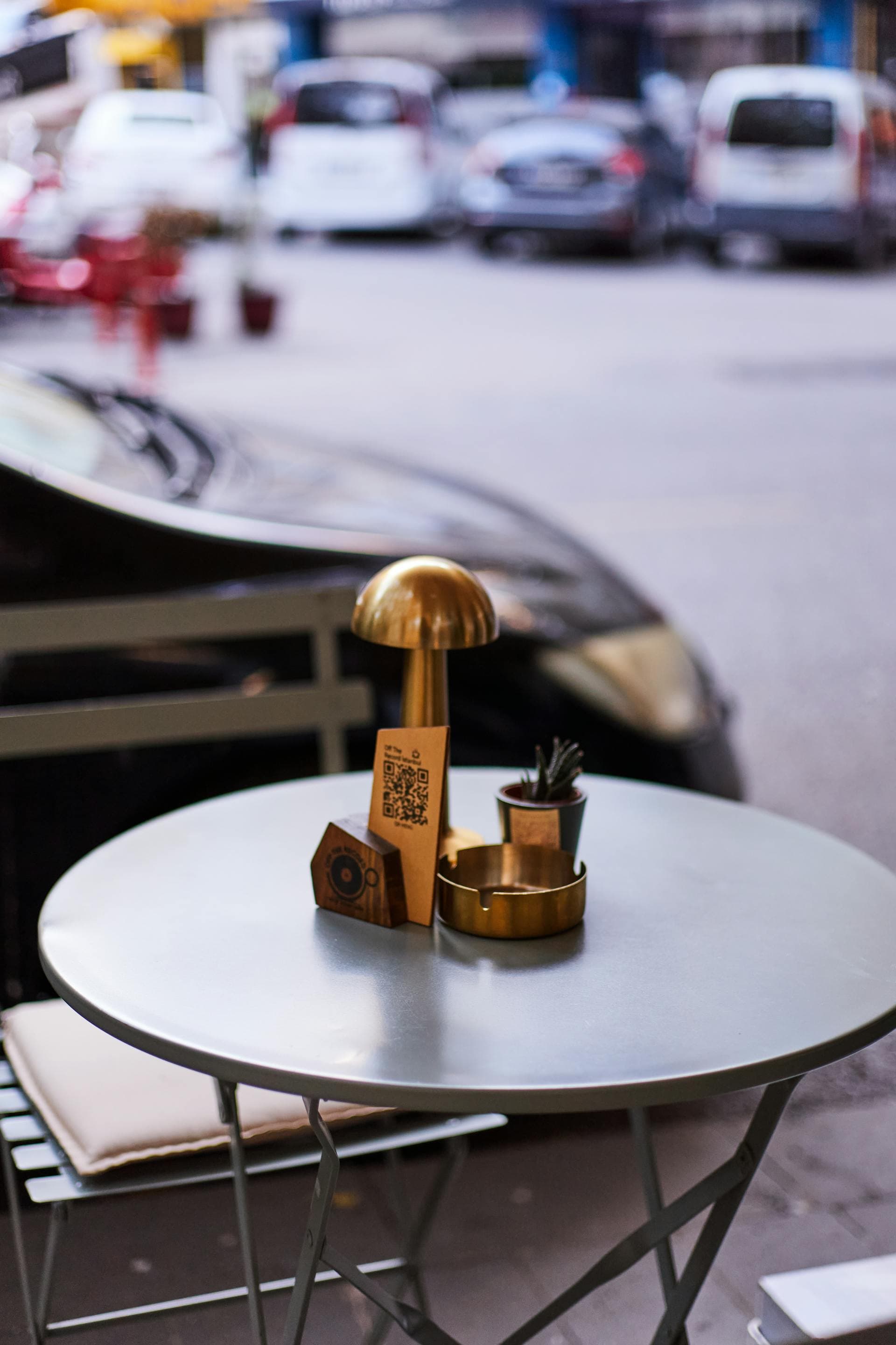 QR code on a restaurant table next to a phone showing a WhatsApp order chat