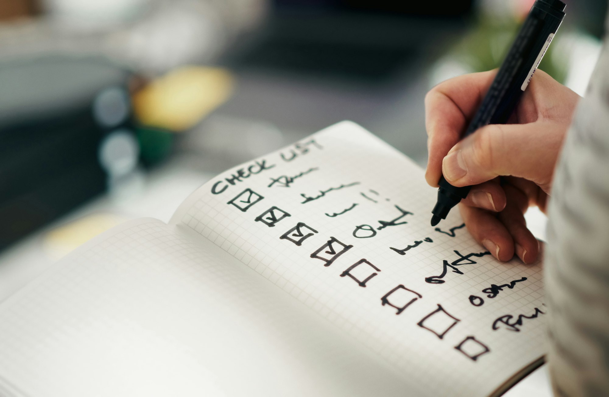 حد بيكتب علامات صح جنب بنود في قايمة "Check List" مكتوبة بخط اليد في نوتة